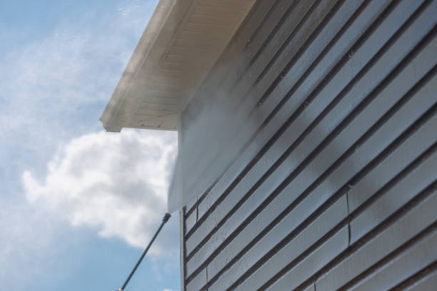 Exterior siding being pressure-washed to remove dirt and buildup before painting by a painter in Dover, MA
