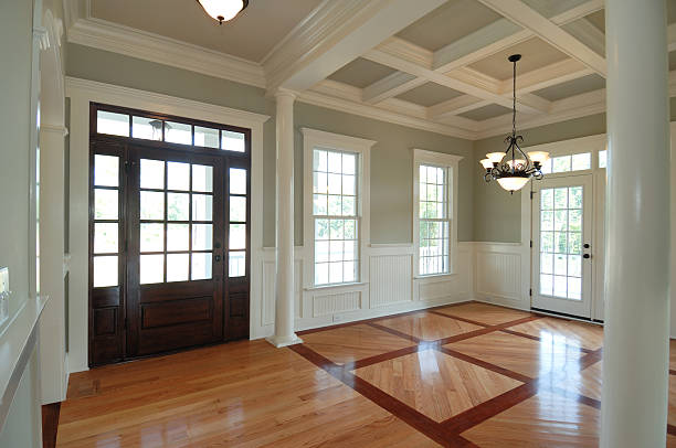 Entryway with soft gray walls, white coffered ceiling, and decorative trim by an interior painter in Holliston, MA.