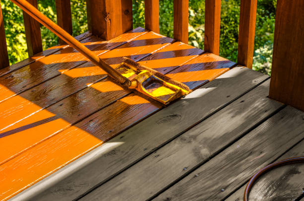 Deck staining and sealing with fresh stain applied to outdoor wood deck boards by a painter in Natick, MA