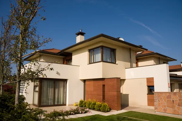 Home with warm neutral exterior paint, contrasting wood-toned finishes, and crisp white trim by painter in Westborough, MA